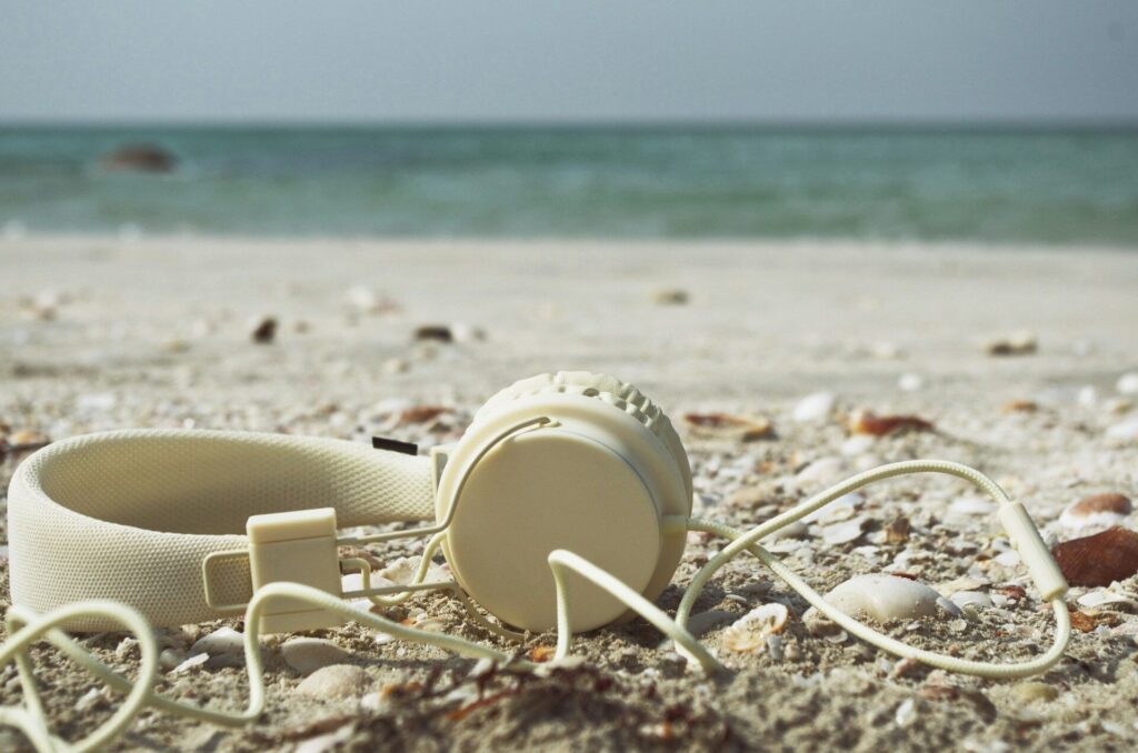 Image of headphones on the beach to illustrate Listening to the Sea. Image by ilyuza-mingazova on unsplash
